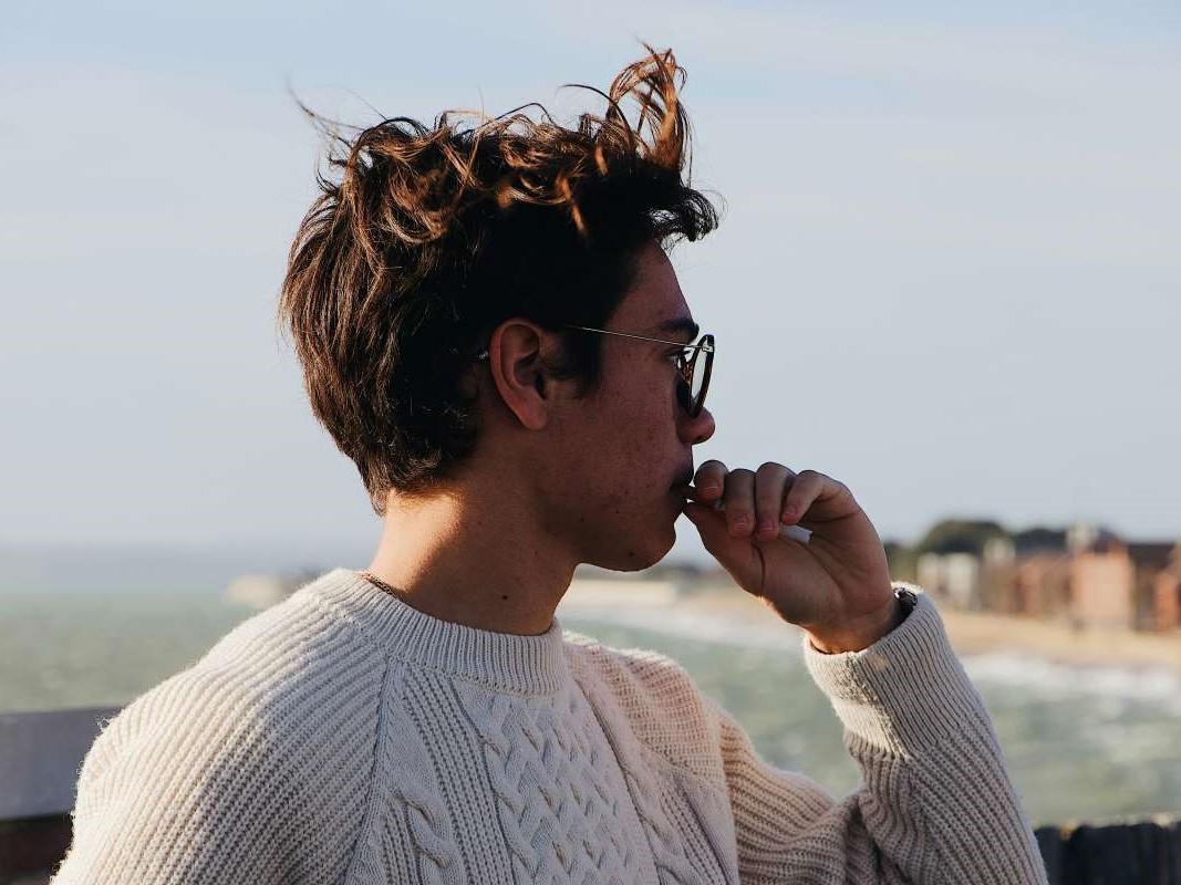 a man with a cigarette hanging at the pier