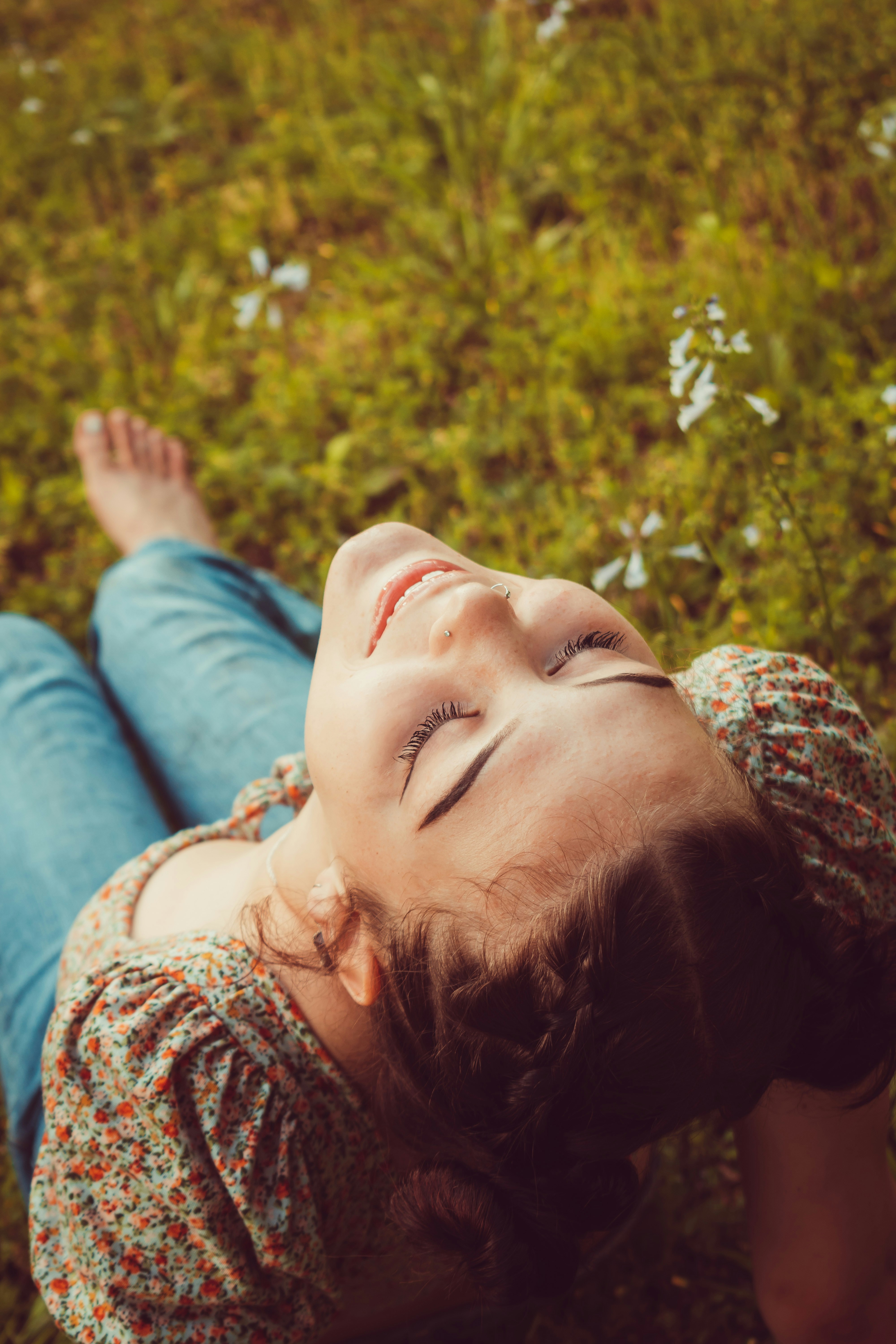 a woman relaxing outdoors on a warm afternoon, smiling contentedly