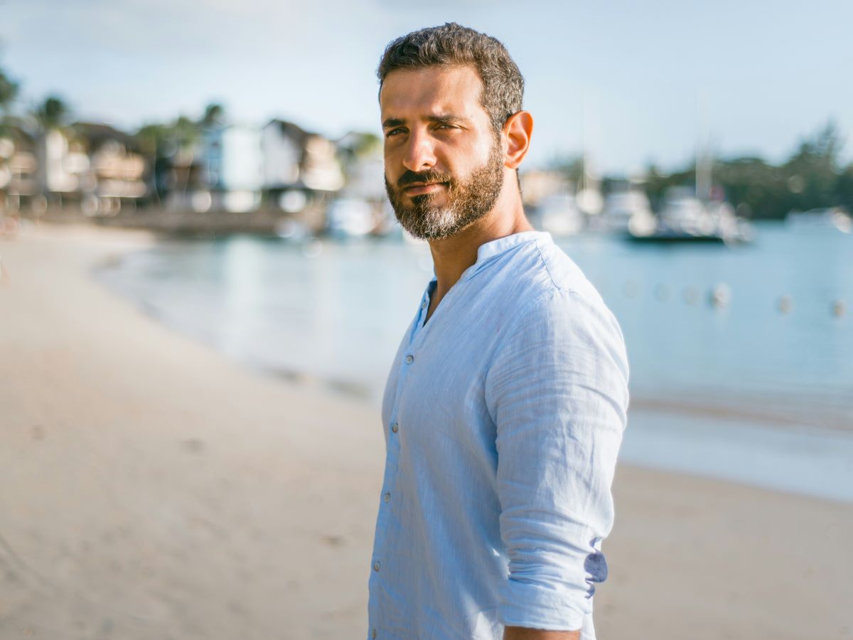 a man at the beach by himself looking at the camera