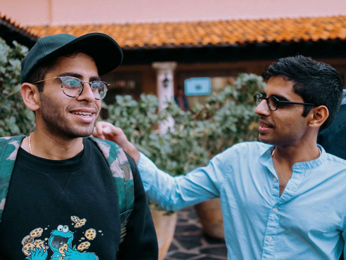 two guys hanging out with one person having his hand on the other shoulder
